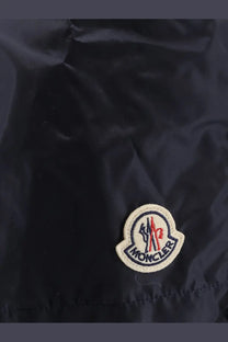 Dark navy moncler puffer jacket with white embroidered logo patch featuring red and blue accents