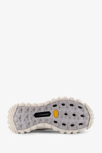 The sole of a gray moncler men’s trailgrip gtx leather and ripstop sneaker with a rugged tread and yellow vibram logo