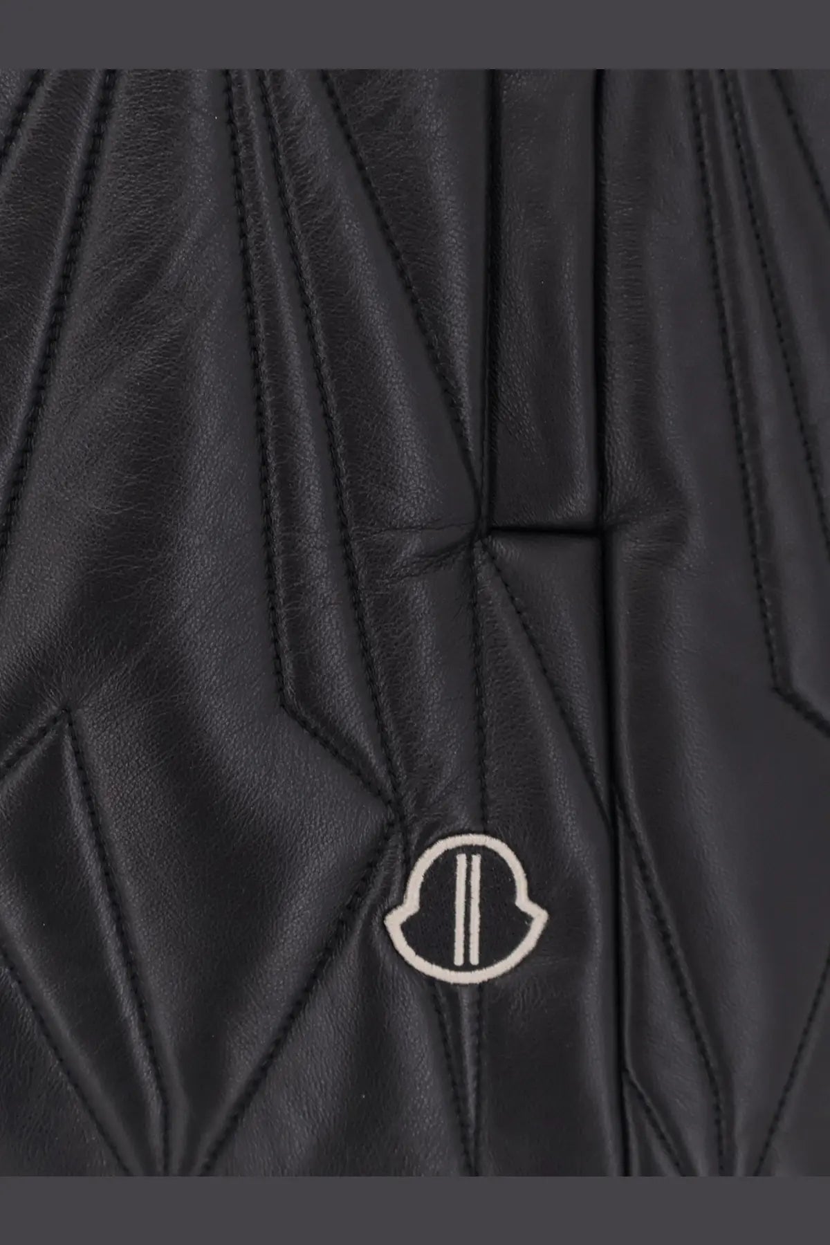 Black quilted leather moncler jacket with subtle white logo patch in the moncler rick owens geocamo flight vest style