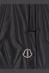 Black quilted leather moncler jacket with subtle white logo patch in the moncler rick owens geocamo flight vest style