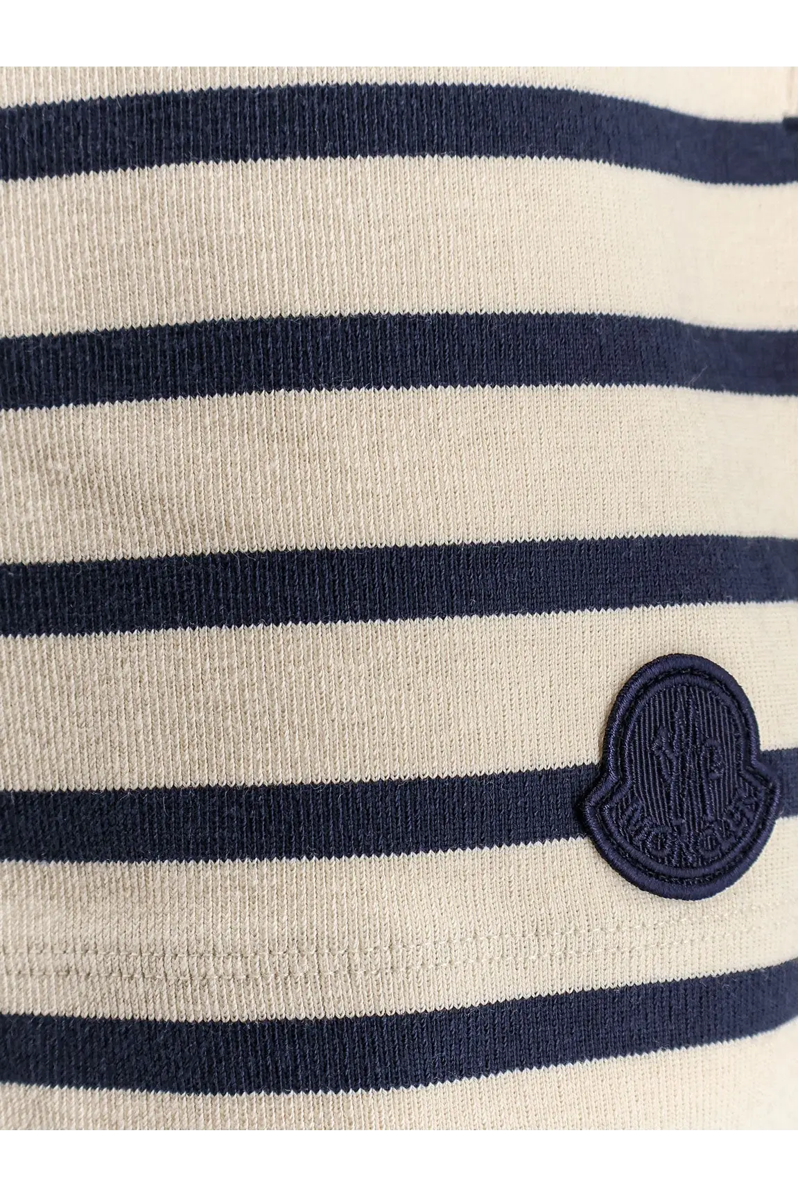 Moncler women’s black cotton shorts paired with cream-colored and navy blue striped knit top with embroidered logo patch