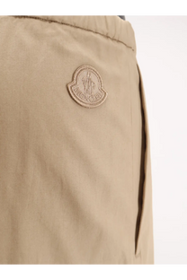 Beige moncler logo patch on khaki cotton fabric of women’s cotton trousers showing front side detail