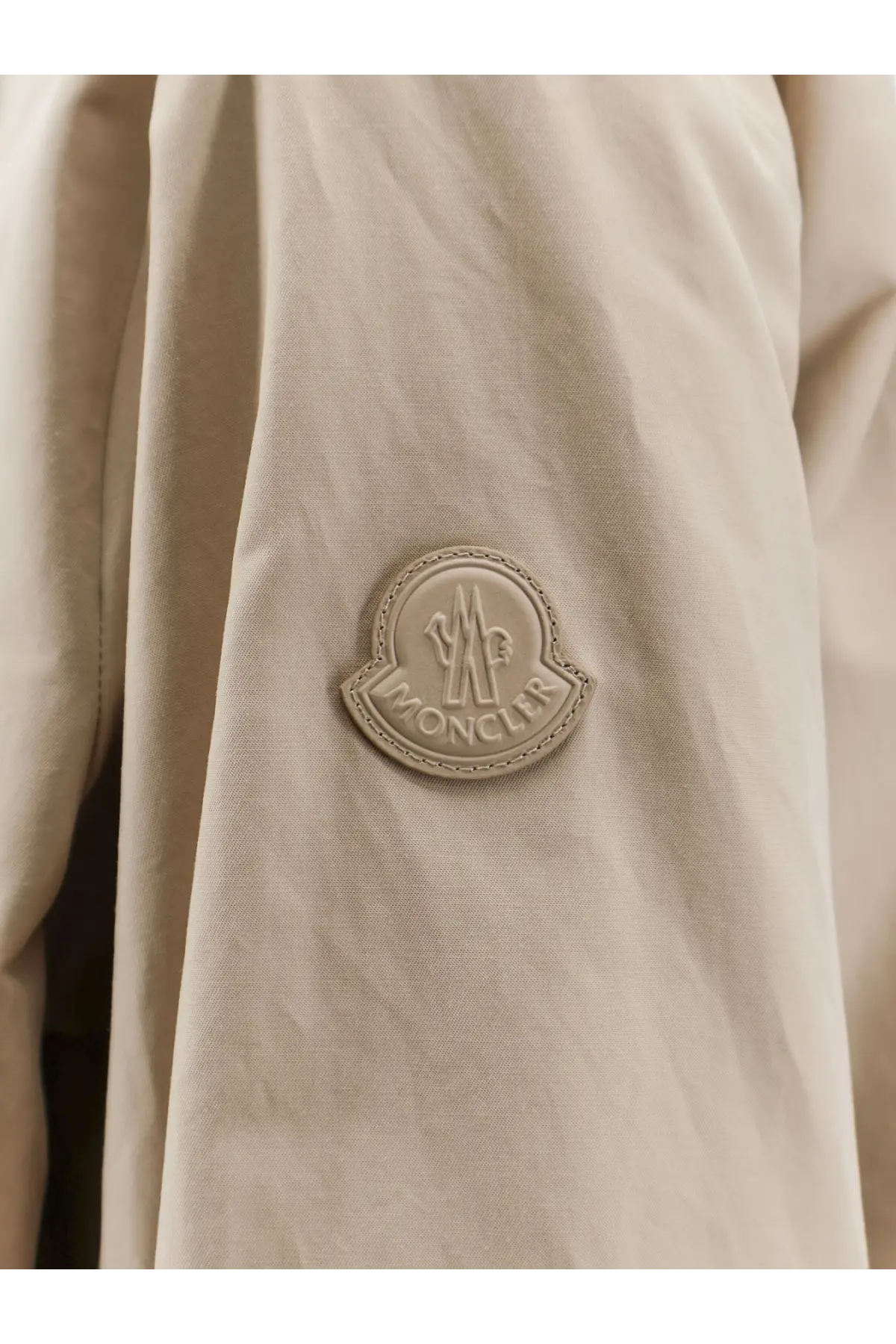 Beige moncler logo patch on the front of a light-colored moncler women’s gruissan jacket