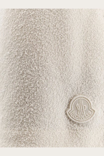 Beige textured wool coat with matching embroidered moncler logo patch shown with moncler women’s nylon shorts white