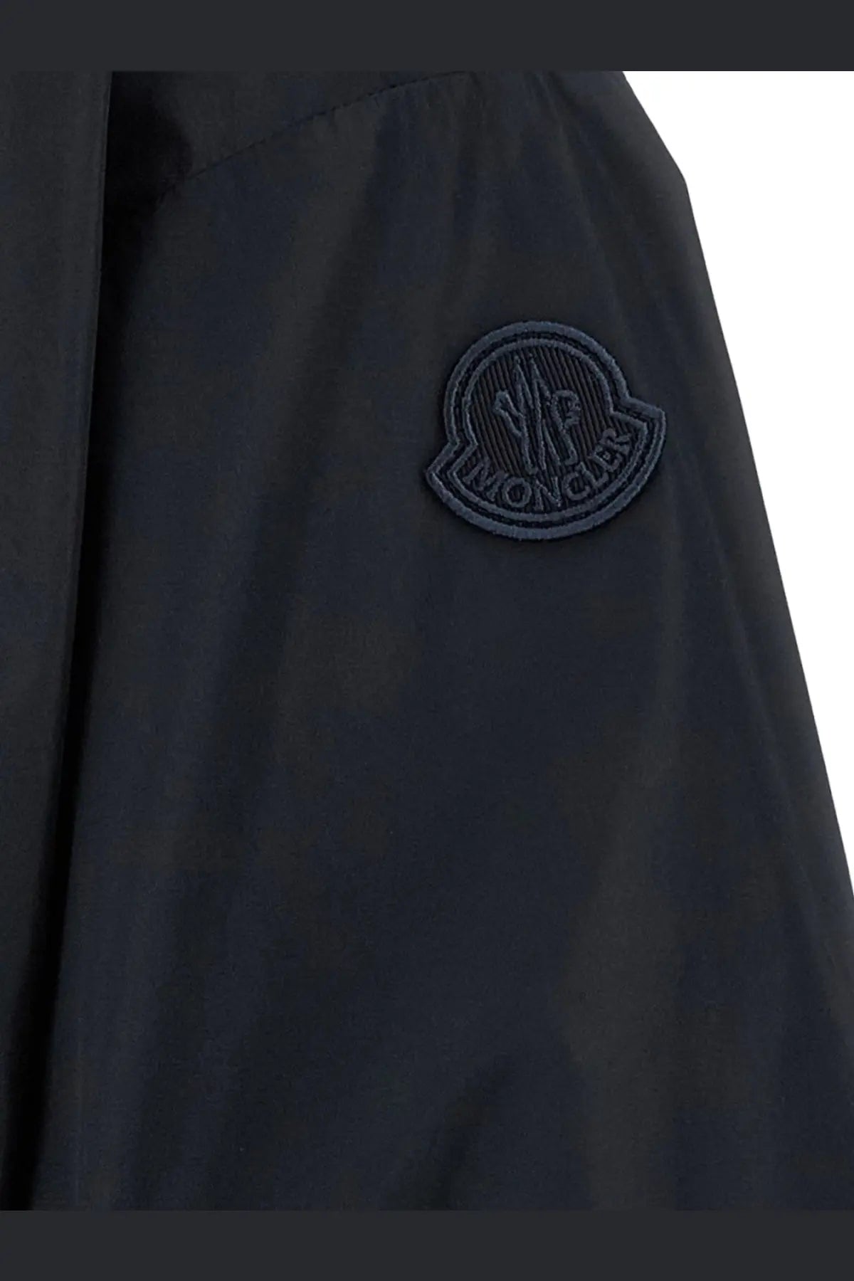 Dark navy moncler logo patch on the sleeve of a sleek blue water-resistant nylon women’s pecher jacket