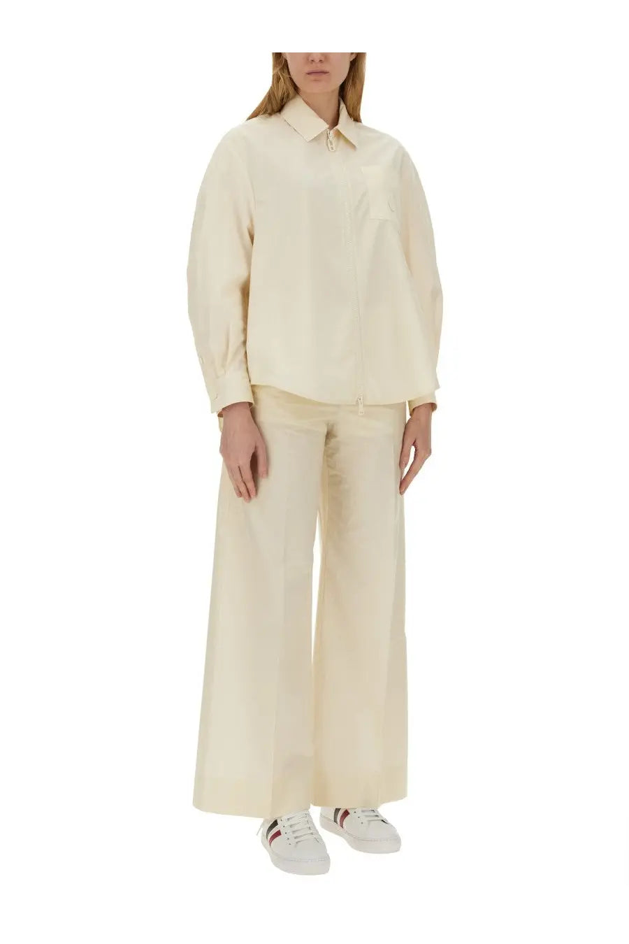 Cream-colored loose-fitting cotton blouse with classic collar and long sleeves paired with moncler white poplin pants