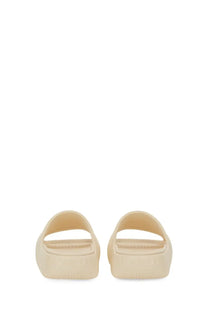 Moncler women’s cream-colored slide sandals with minimalist design and smooth molded rubber platform sole