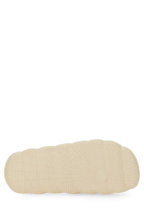 Cream-colored rubber sole with textured wavy pattern on the back side of moncler women’s slide sandal white