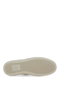 Beige rubber sole with hexagonal tread and rectangular brand label on the back of moncler womens white sneaker
