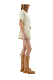 Moncler women’s technical twill shorts beige cream romper with drawstring waist front pockets and tan Moncler leather boots
