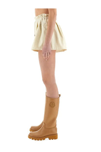 Tan moncler logo boots with chunky sole and smooth leather upper paired with beige moncler women’s technical twill shorts