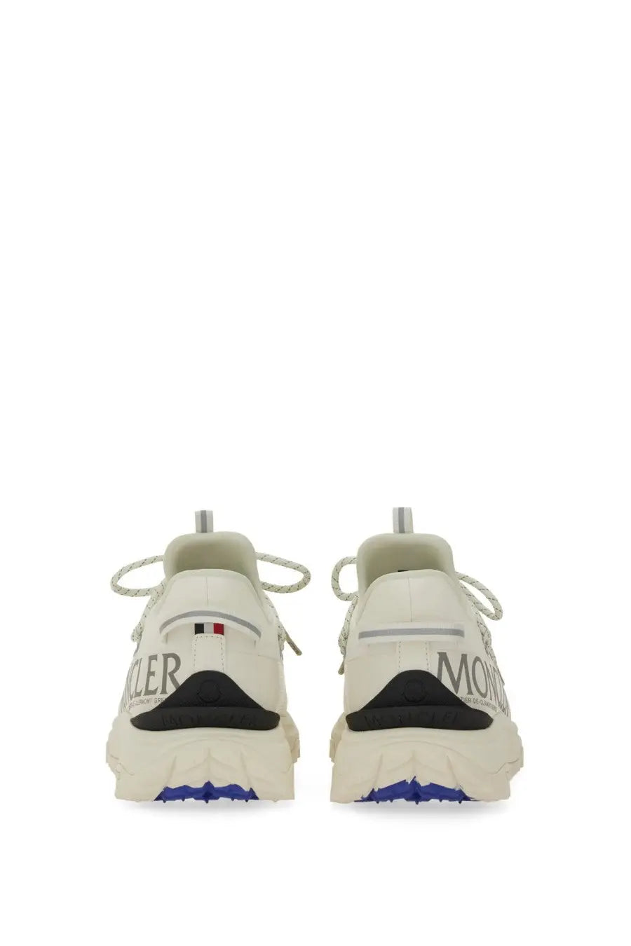 White moncler women’s trailgrip lite sneaker in beige with black and blue accents and textured rubber sole visible from back