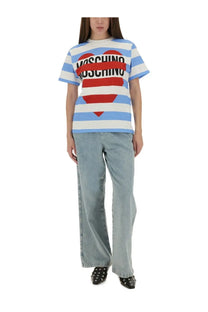 Blue and white striped short-sleeved t-shirt with red heart graphic and moschino text paired with denim blue jeans