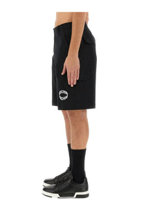 Moschino men’s black cargo shorts with a circular white logo on the left thigh ideal for casual wear