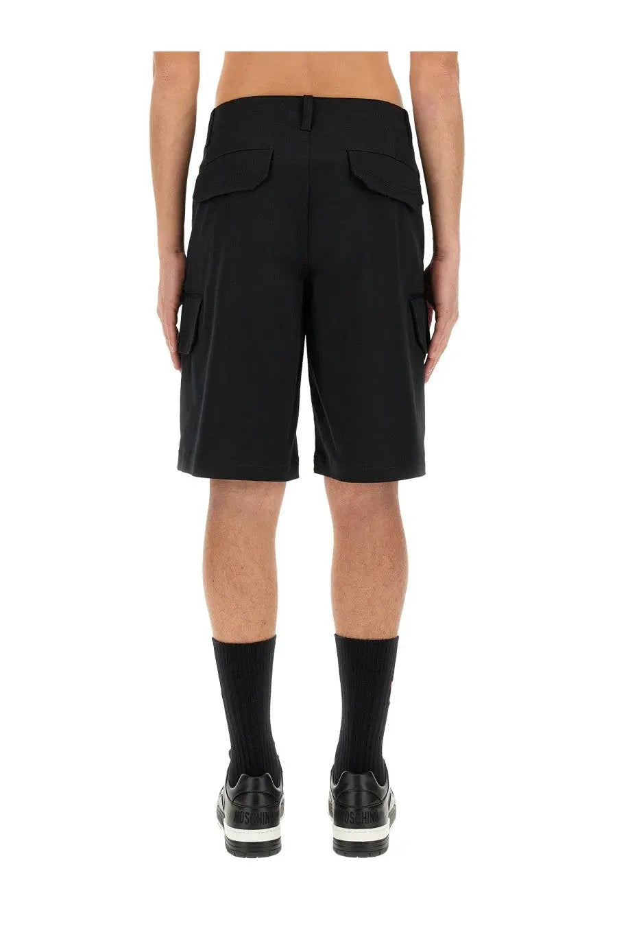 Moschino men’s Bermuda black cargo shorts in structured fabric with two back flap pockets and side pockets shown from back