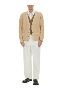 Beige ribbed knit cardigan with brown buttons and front pockets paired with moschino men’s denim white jeans