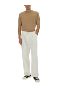 A pair of crisp white pleated trousers with a clean minimalist design paired with moschino men’s wool and silk beige sweater