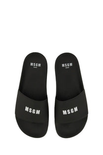 Black msgm women’s slide sandals with white logo branding on the footbed and strap for casual wear