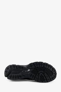 Black rubber sole of new balance men’s gore tex sneakers featuring textured geometric tread and subtle branding details