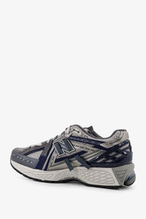 New balance men’s mesh sneakers in grey featuring gray and navy blue running shoe with mesh and synthetic overlays