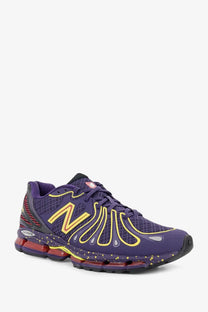 New balance men’s mesh sneakers in purple with yellow accents and red air cushion for running performance