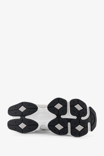 New balance men’s white mesh sneakers with black chunky sole and diamond-shaped rubber grips on the outsole