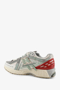 New balance men’s mesh sneakers in gray and red with synthetic overlays and a chunky midsole for comfort