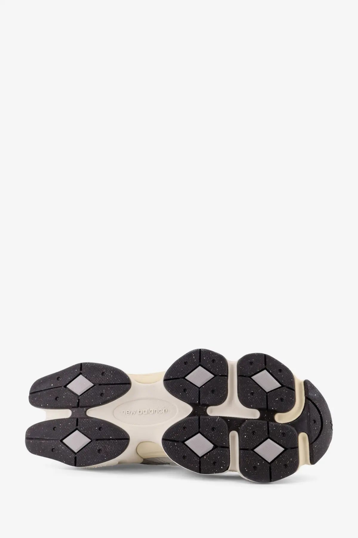 Cream-colored new balance men’s mesh and suede sneaker sole with black diamond-shaped tread and speckled texture