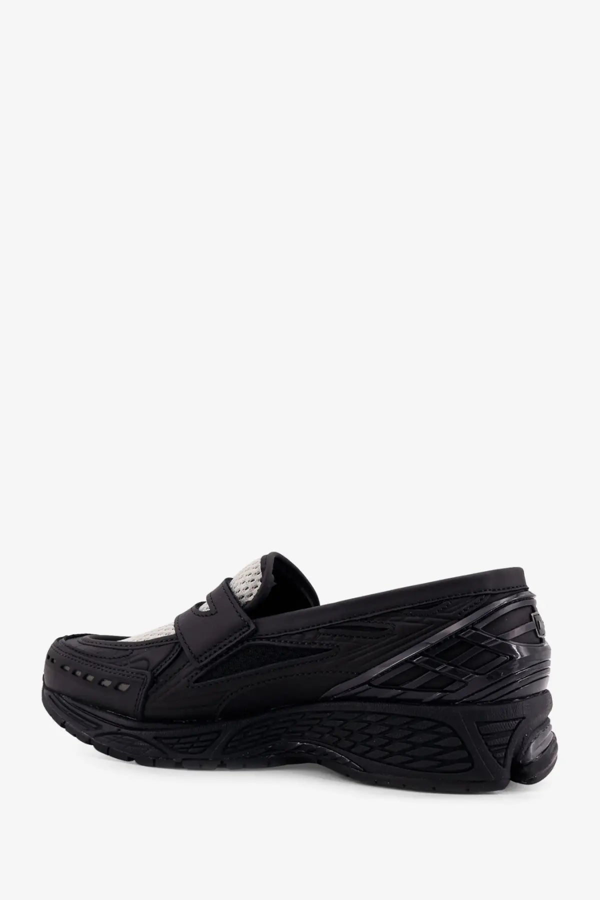 New Balance men’s black loafers with sleek modern design, subtle white mesh accents, and textured rubber soles