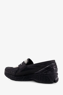 New Balance men’s black loafers with sleek modern design, subtle white mesh accents, and textured rubber soles
