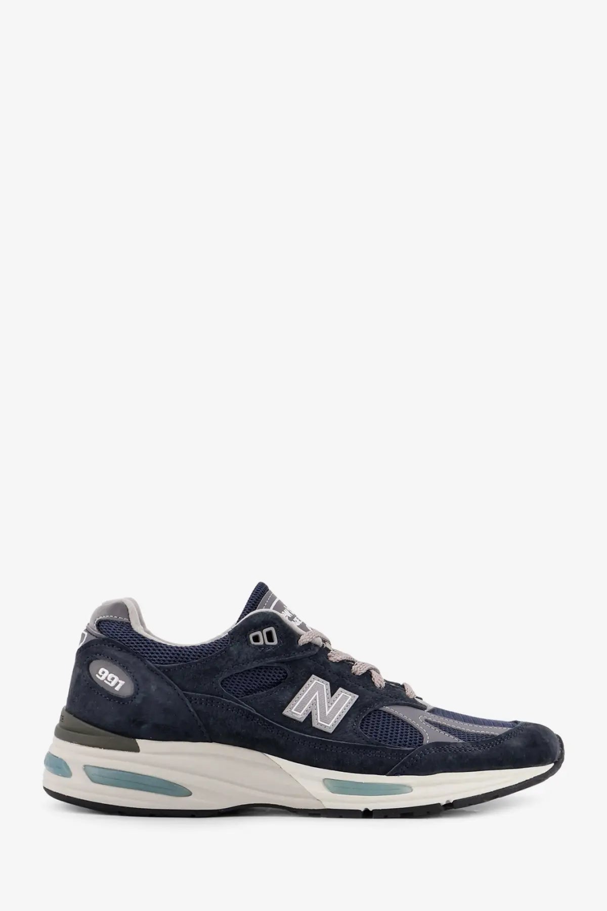 New Balance men’s suede low top sneaker in navy blue with suede and mesh materials and teal midsole accents