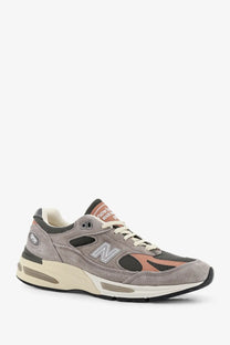 New Balance men’s suede and mesh sneakers grey with peach accents black detailing and cream midsole front view
