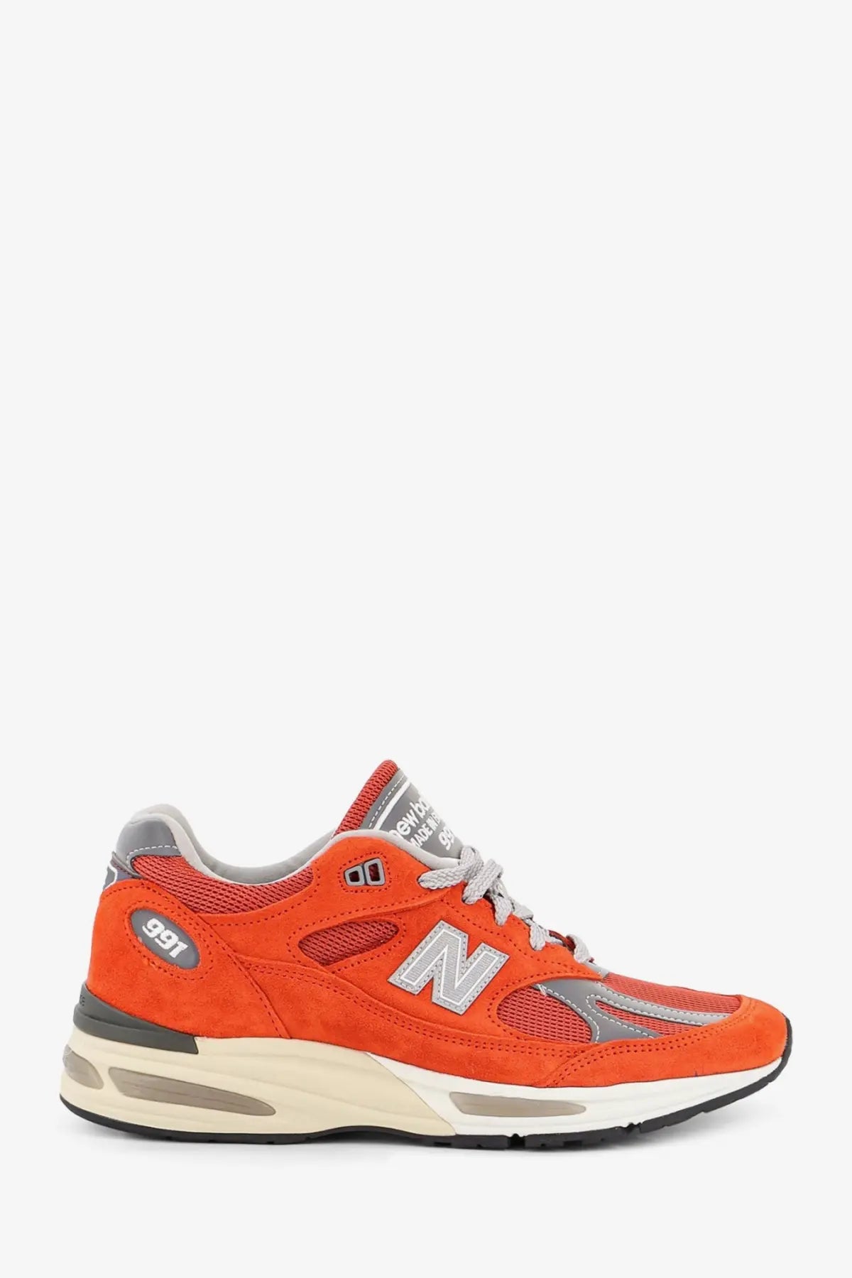 New Balance men’s suede sneakers in vibrant orange with mesh accents gray details and white midsole