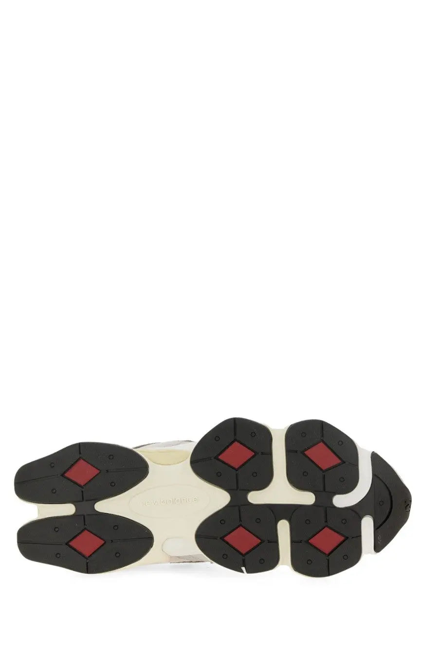 New Balance unisex sneaker grey with black and red diamond-patterned rubber sole and cream-colored midsole