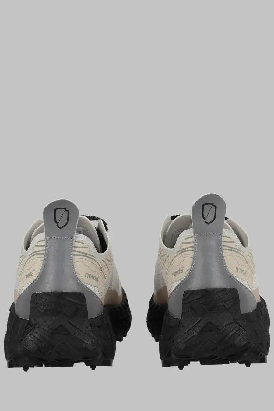 A pair of norda women’s sneaker cinder bio dyneema gray trail running shoes with cream and gray upper and black soles