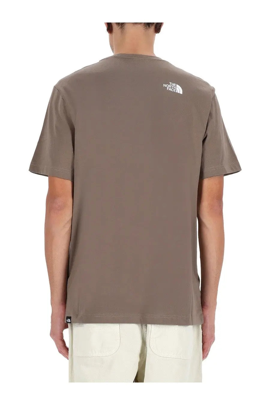 The back of a taupe brown north face men’s simple dome short-sleeved shirt with a white logo and black hem tag