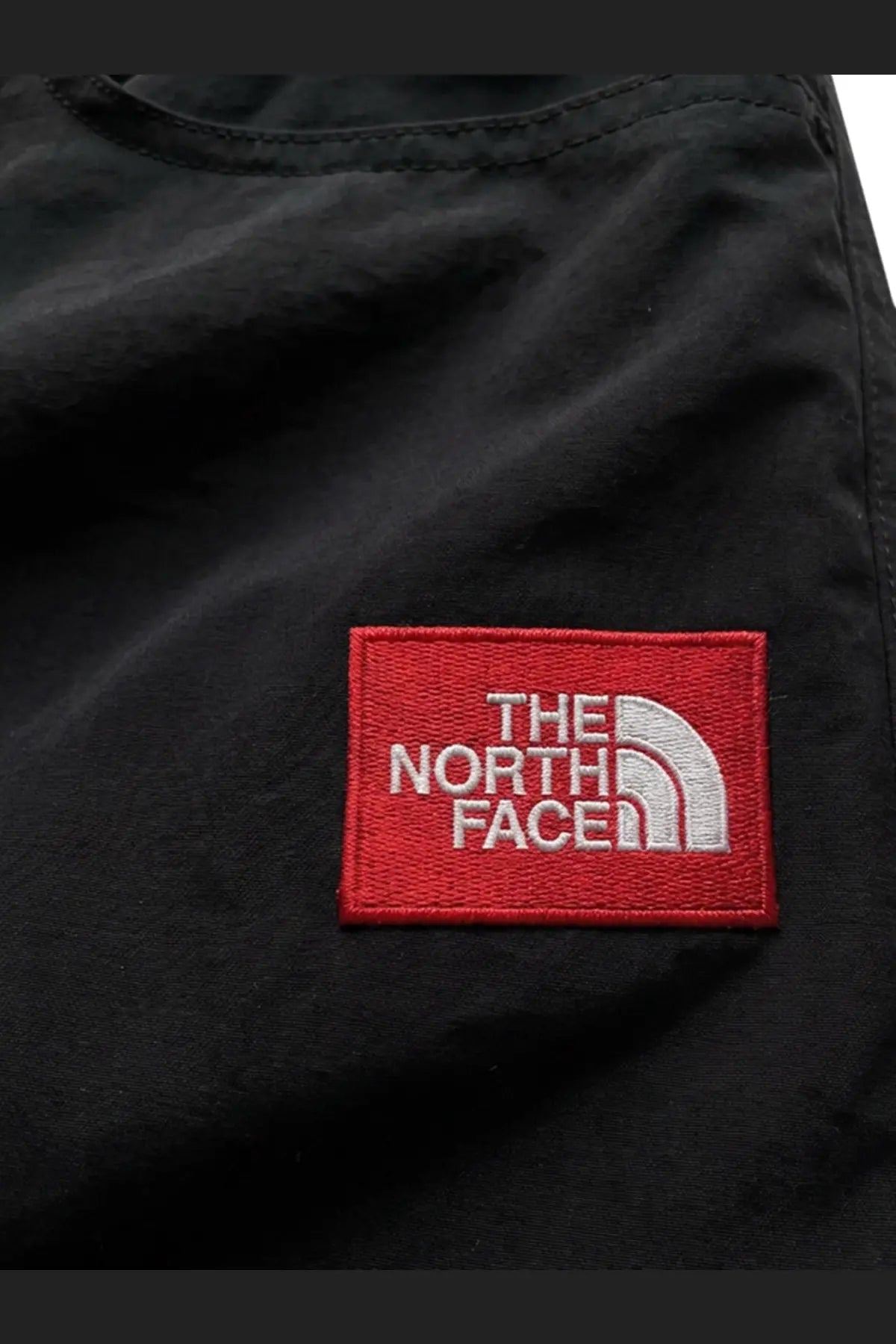 Black the north face patch with red border and white embroidered logo on mens tnf nylon bermuda shorts black