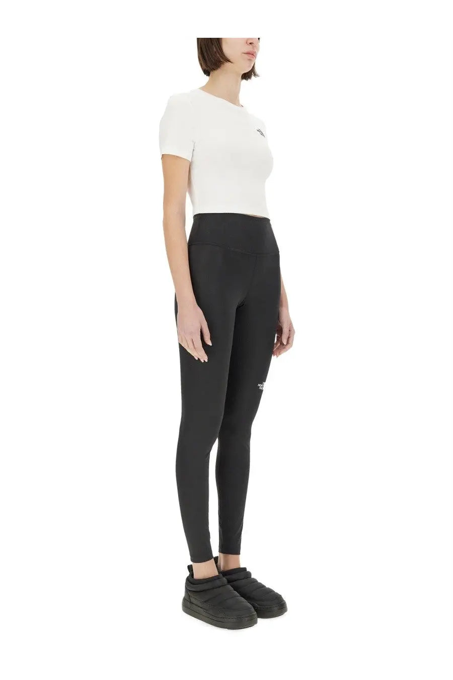 Black high-waisted leggings with subtle logo on thigh and hip paired with the north face women’s cropped shirt white