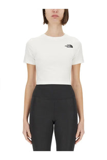 The North Face women’s white short-sleeved cropped shirt with black logo on chest is lightweight cotton blend