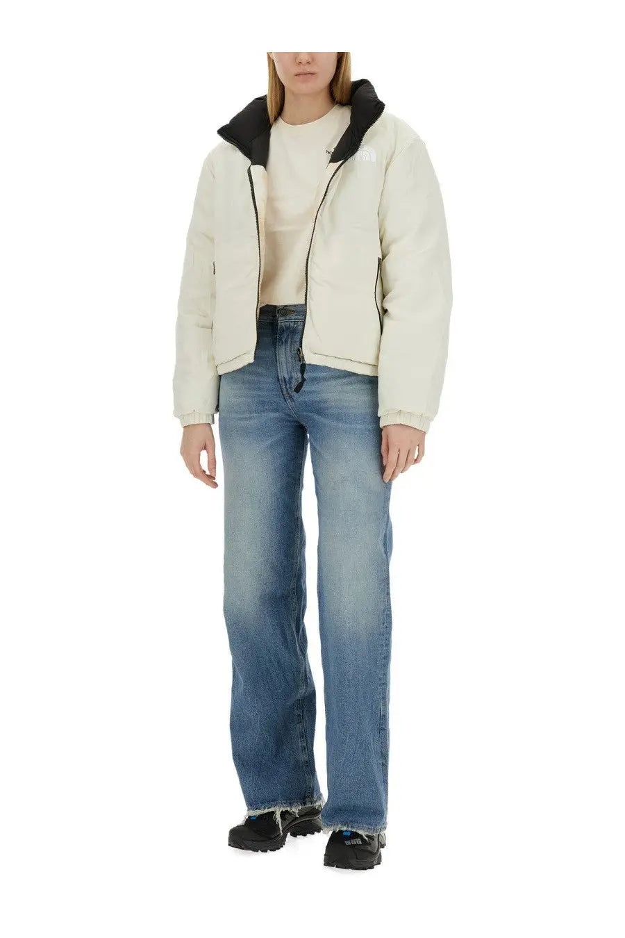 The North Face women’s down jacket in cream color features a puffer style with black-lined hood and zipper details