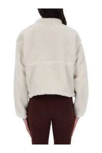 The North Face women’s extreme jacket is a cream-colored plush faux fur cropped jacket with a high collar and relaxed fit