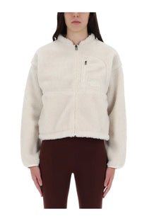 The North Face women’s extreme jacket white is a cream-colored plush fleece jacket with a front zipper and chest pocket