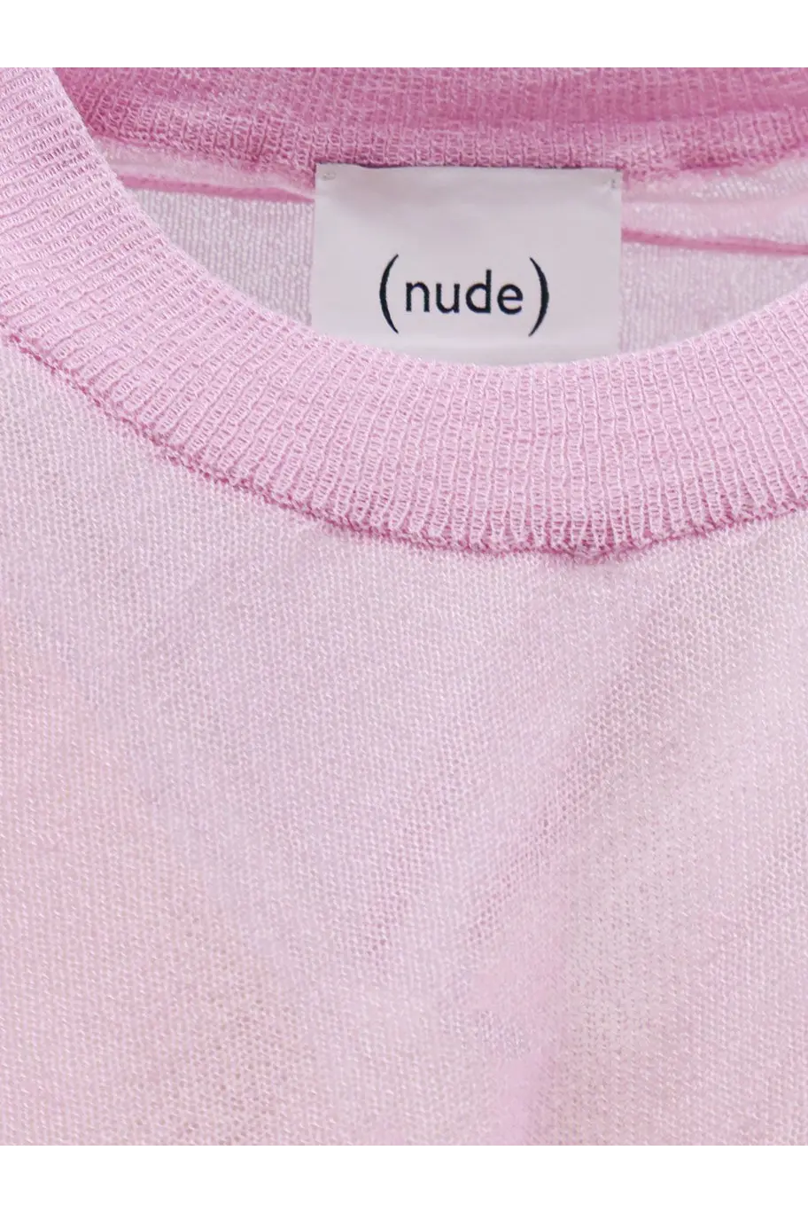 A soft pink knit cotton blend shirt with a ribbed neckline and a white label reading nude for women