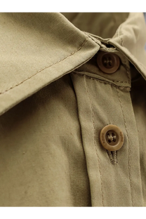 Beige button engraved with mille on the collar of a nude womens green cotton shirt made of khaki fabric