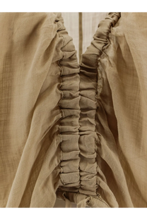 Nude women’s linen blend shirt in beige with gathered ruching along the side seam visible from the back side