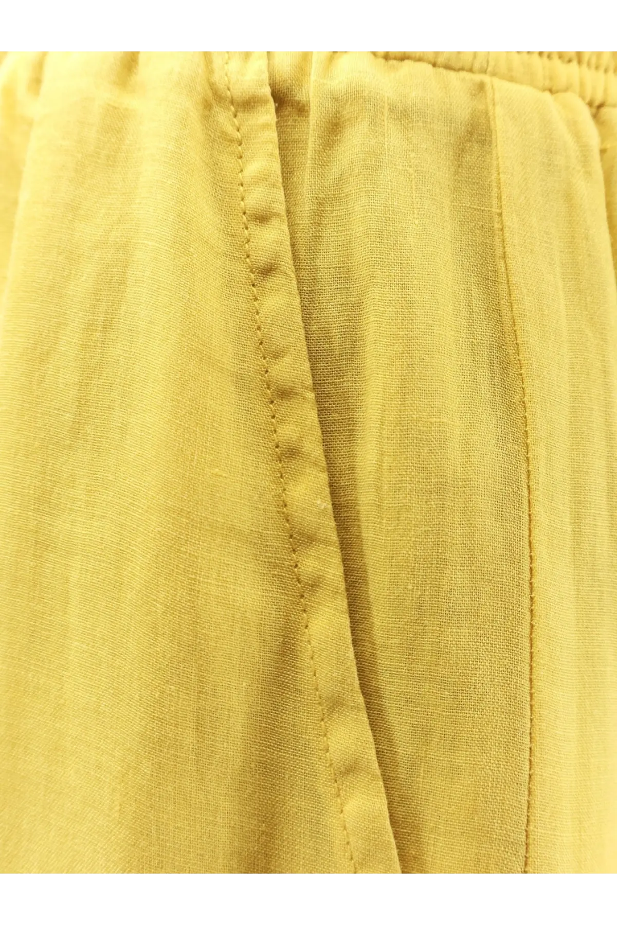 Nude women’s linen blend trousers cedar shown from the back with relaxed yellow linen pants featuring visible stitching