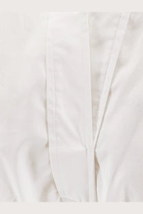 White cotton fabric with neat straight stitching on seams of nude women’s polo cotton dress white