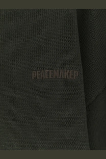 Dark olive green knitted cotton sweater with peacemaker embroidery in matching thread from oamc men’s collection