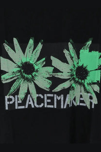 Oamc peacemaker men’s black cotton t shirt with bold green daisies and white peacemaker text print on front
