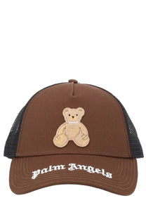 Brown trucker hat with beige embroidered teddy bear patch and white palm angels lettering on brim for men